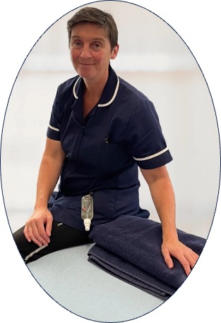 Evonne Foulkes, mobile injury treatments specialist, sits on a treatment couch with a hand on a folded towel, dressed in a tnavy herapist tabard.