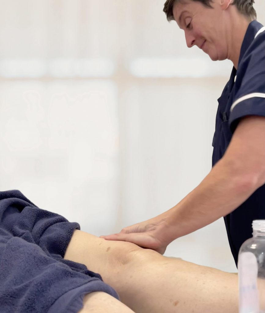 Evonne massages a patient's leg to ease pain and tension